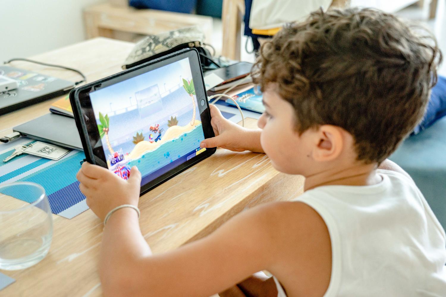 Niño utilizando una tablet para jugar, representando la versatilidad de Moonlight para usar dispositivos móviles como clientes.