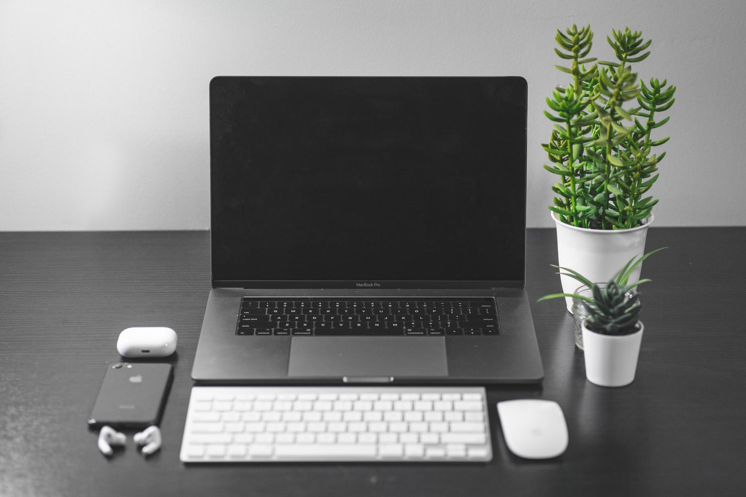 Espacio de trabajo minimalista y moderno con plantas y tecnología, simbolizando un entorno digital optimizado.