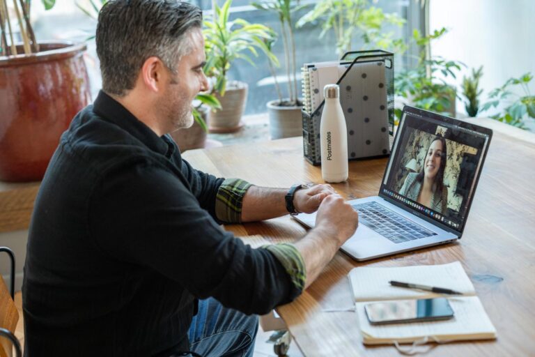 Hombre profesional participando en una reunión virtual desde su espacio de trabajo en casa.
