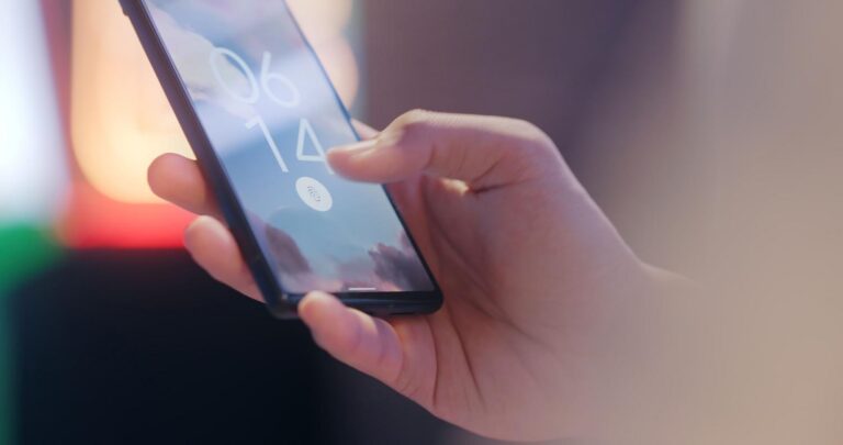 Persona utilizando el sensor de huellas dactilares de un smartphone para autenticación biométrica