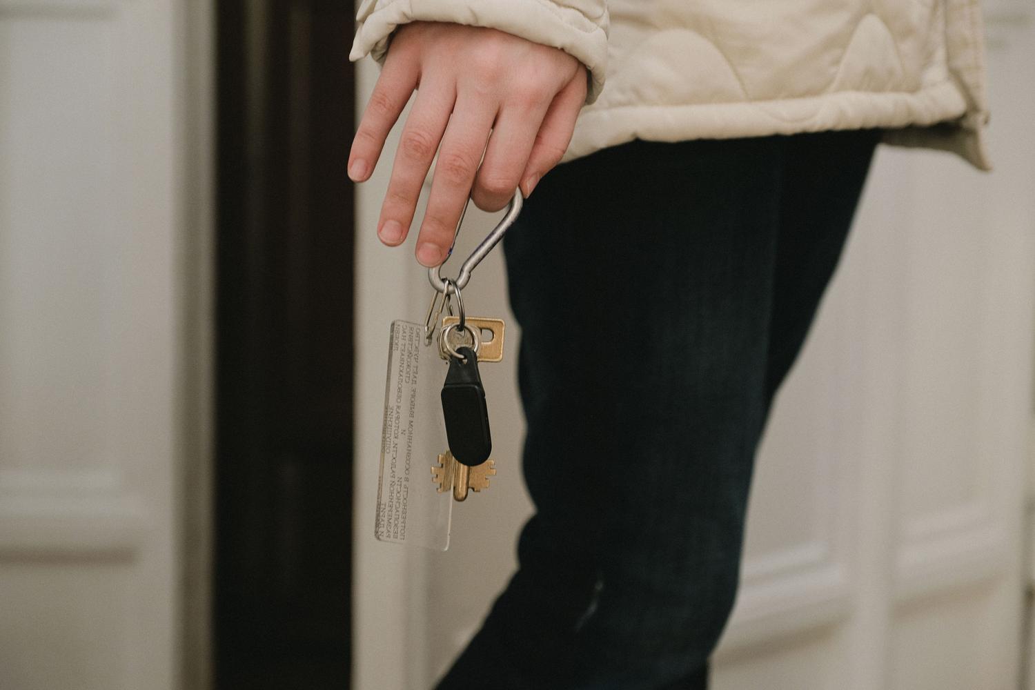 A hand holding house keys, one of the objects that Find Hub can help you remember.