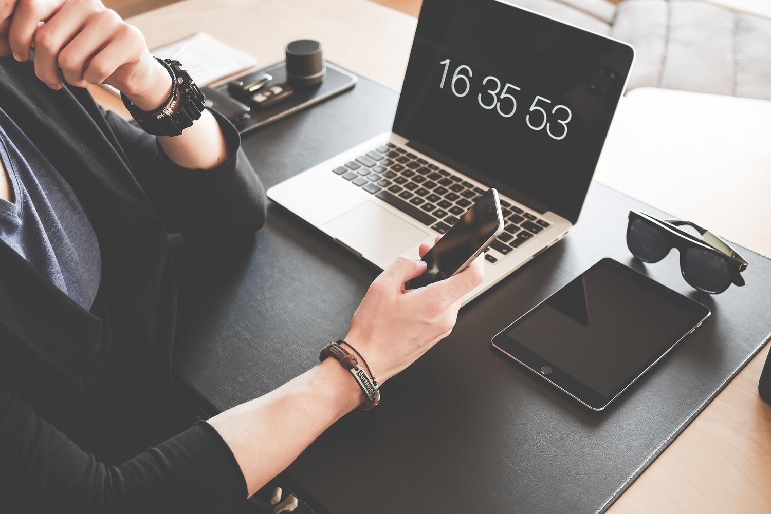 Espacio de trabajo moderno con portátil, tablet y móvil, reflejando un entorno de alta productividad digital.