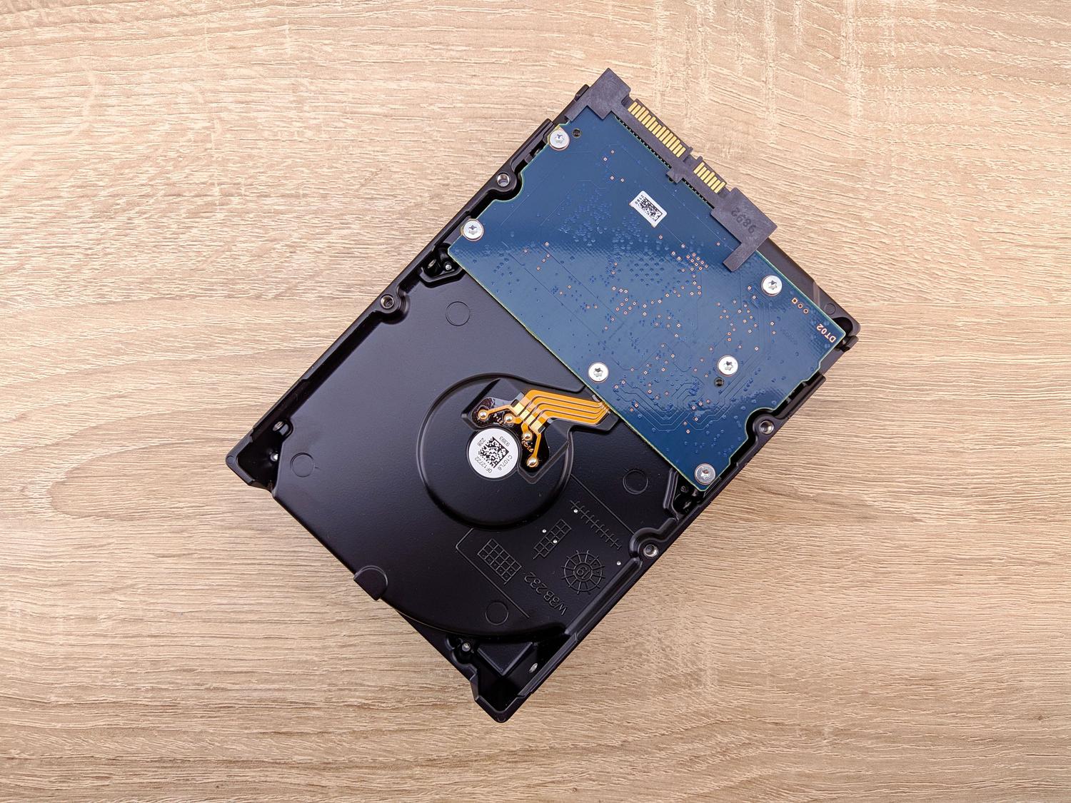 Un disco duro interno moderno sobre una superficie de madera, representando el hardware de almacenamiento afectado por el proceso SysMain.