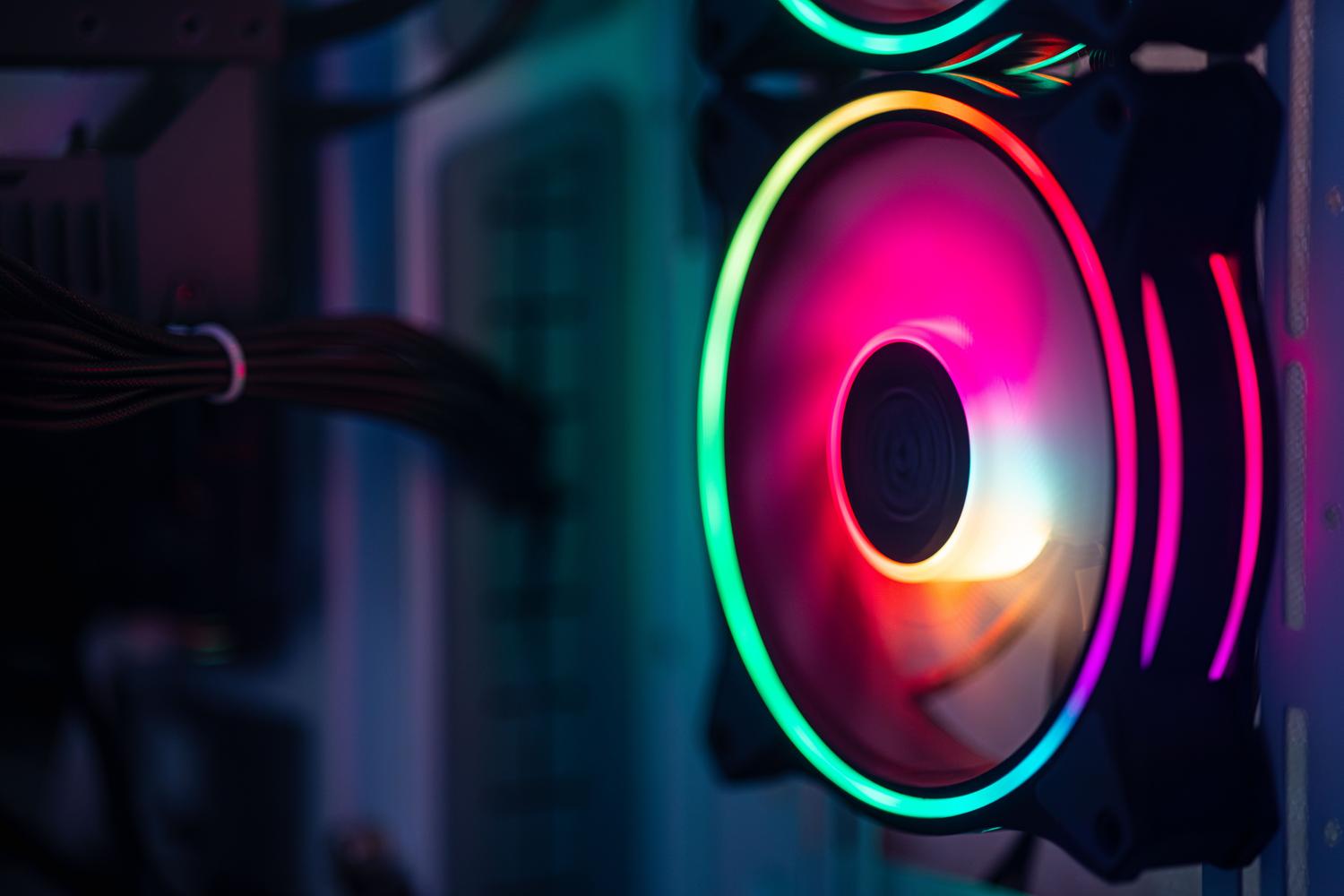 Primer plano de un ventilador RGB colorido dentro de la caja de un ordenador gaming.