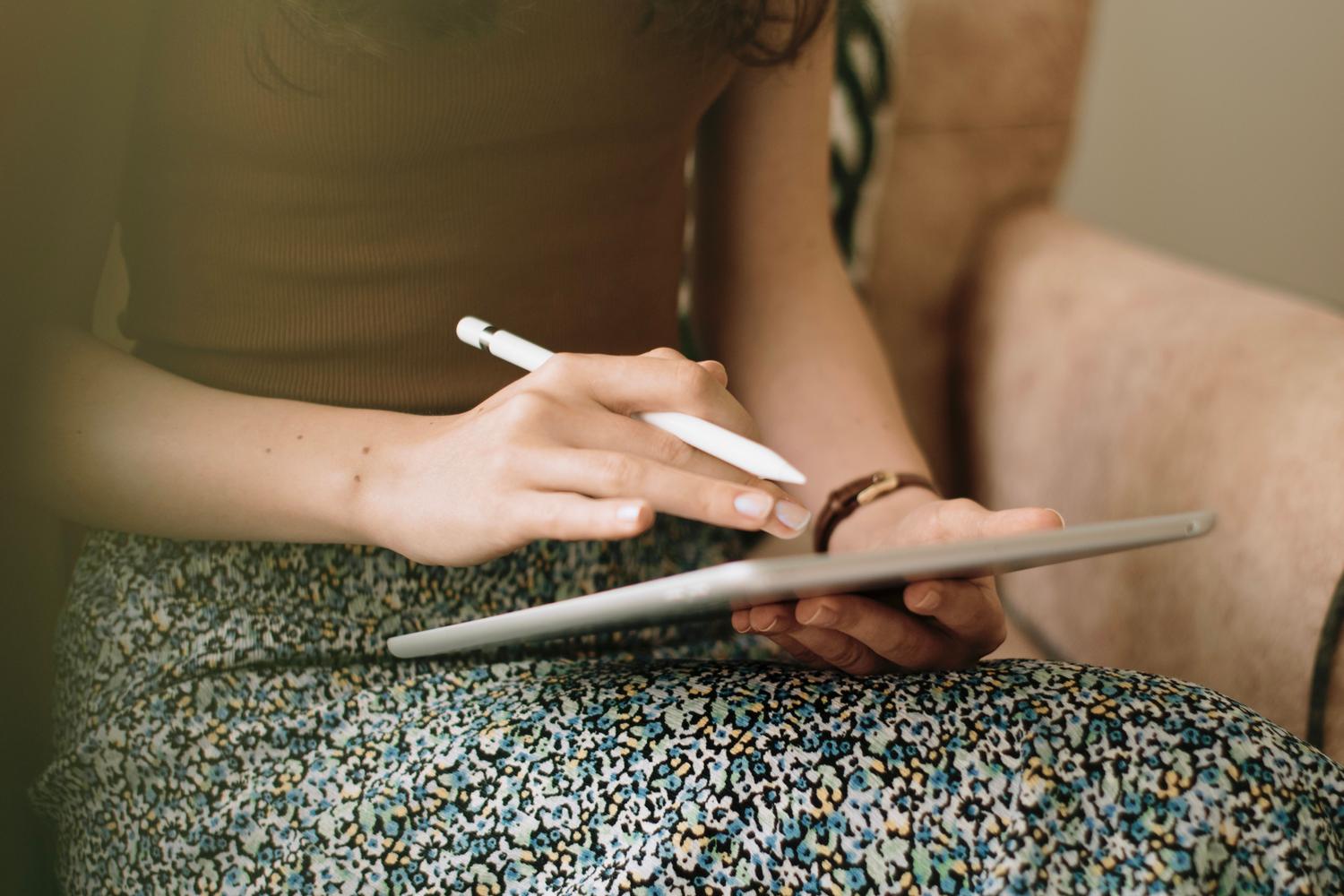 Mano utilizando un lápiz óptico sobre la pantalla de una tablet digital