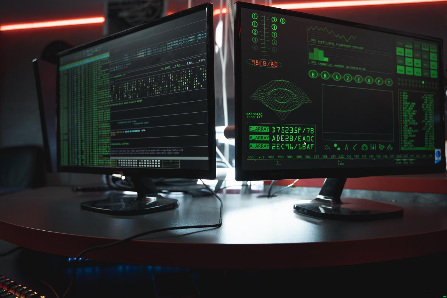 Computer monitors with complex coding interfaces, illustrating the technical operation of COM objects in Windows.