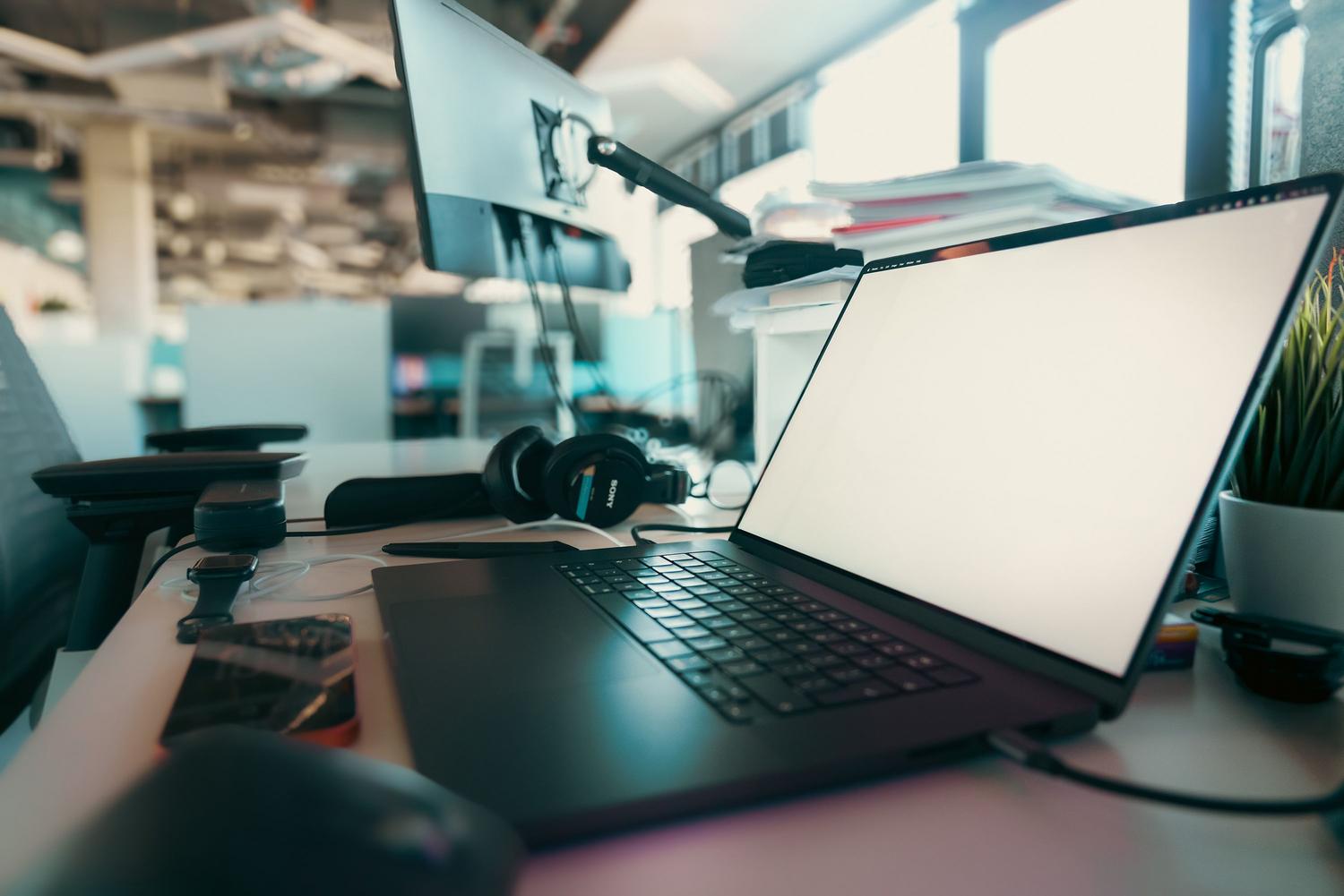 Espacio de trabajo moderno y limpio con portátil y monitor, representando la estabilidad y el rendimiento del sistema.