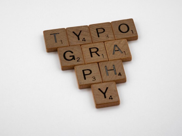 Detalle de fichas de madera formando la palabra Typography, representando la función de renderizado de fuentes del proceso fontdrvhost.exe
