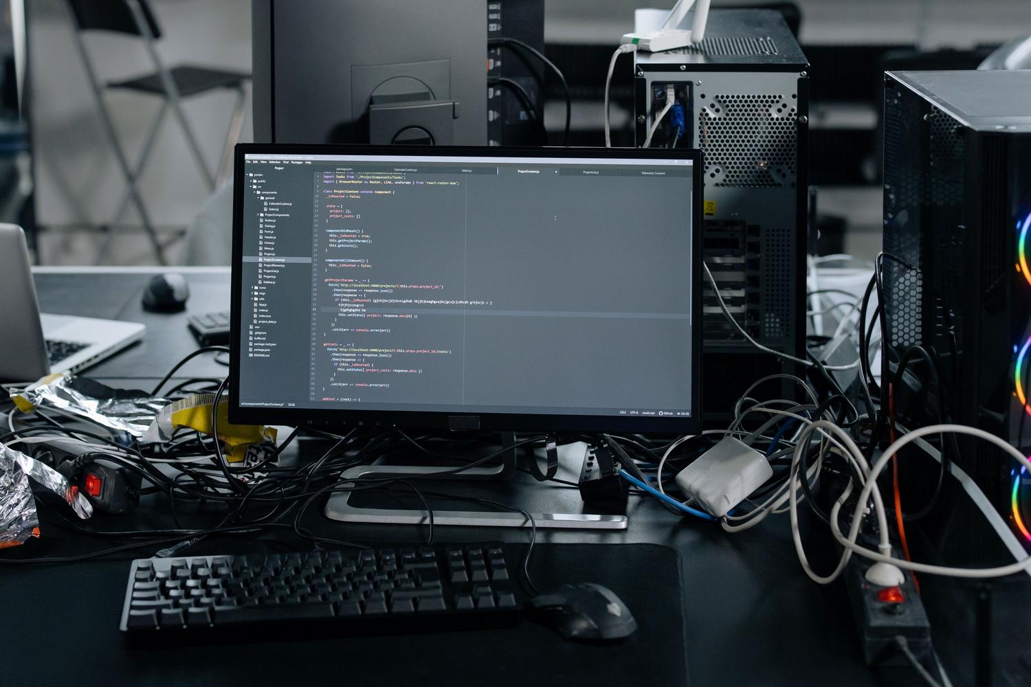 Estación de trabajo con monitor mostrando código, representando la naturaleza técnica de los archivos DLL y ejecutables.