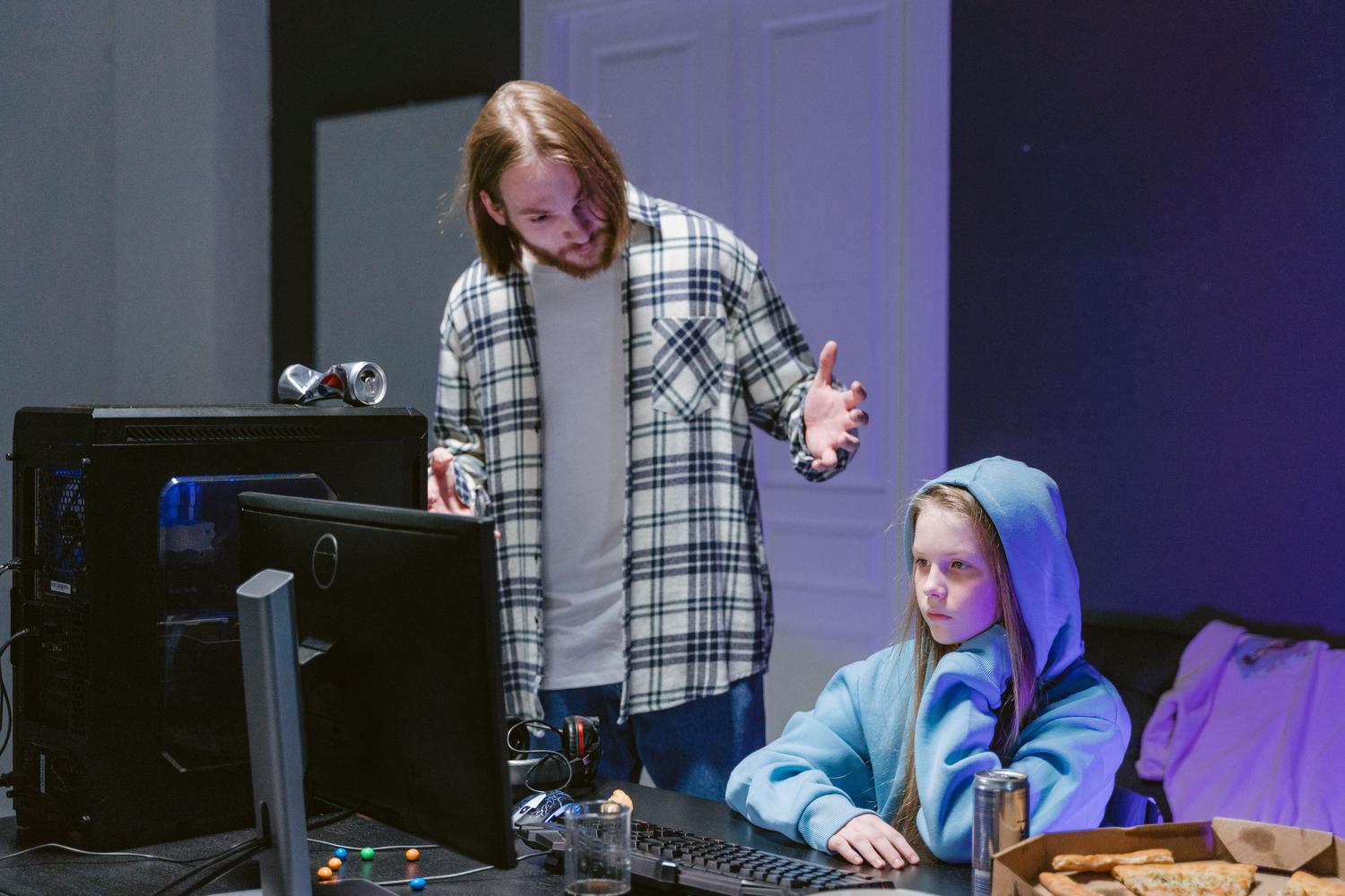 Padre supervisando el uso del ordenador de su hija mediante los controles parentales de Steam Families