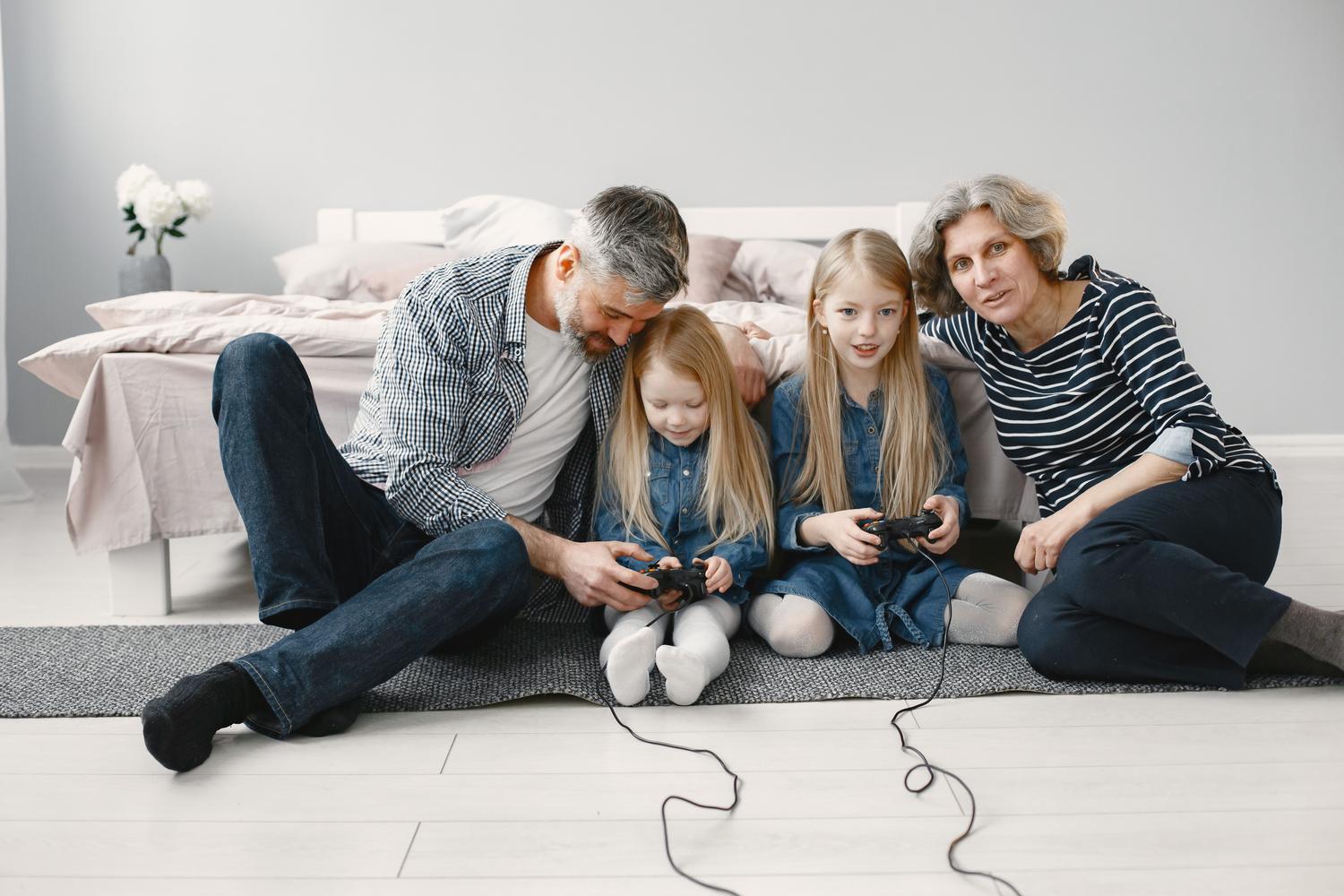 Familia compartiendo un momento de ocio y unión jugando videojuegos juntos en el salón