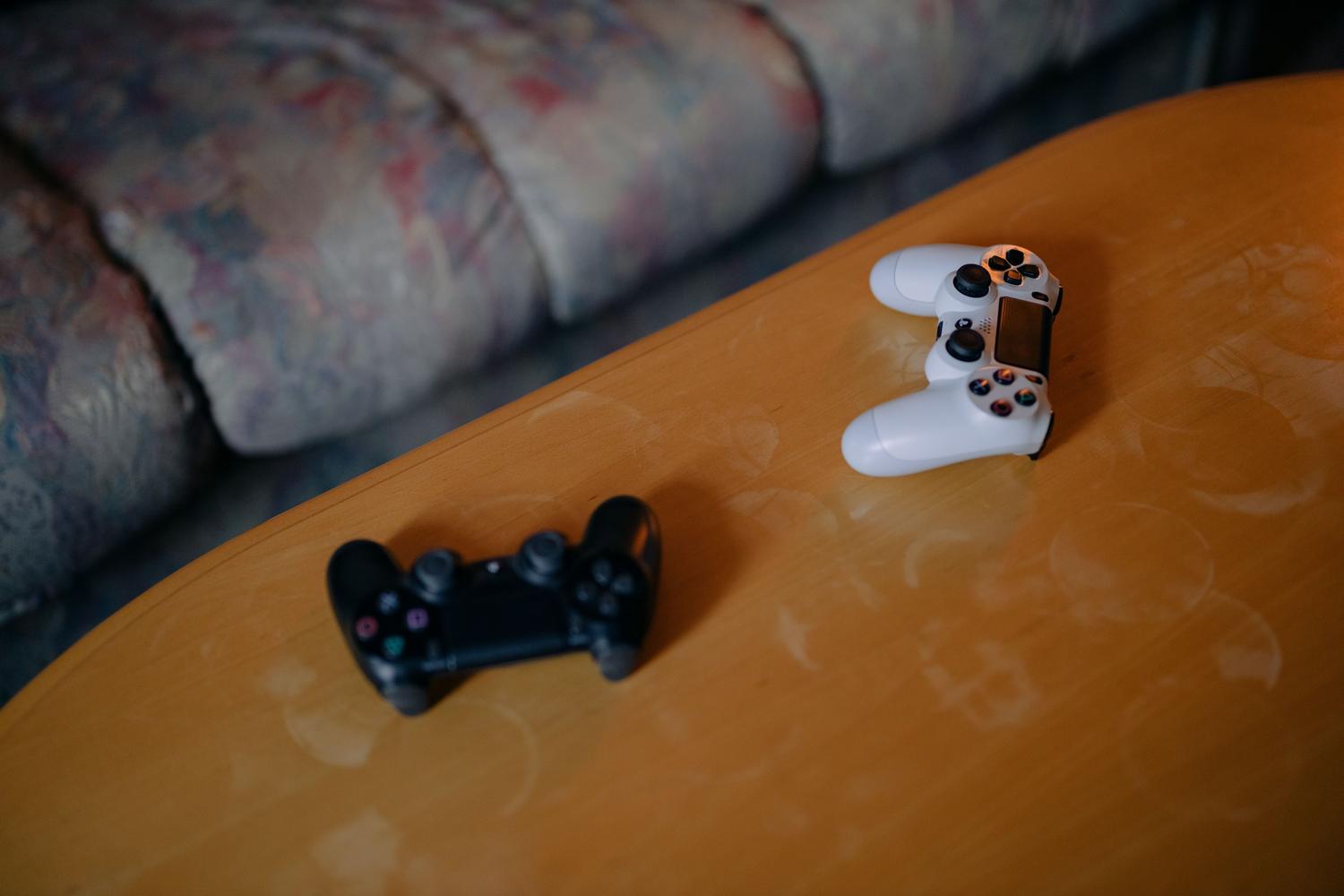 Wireless video game controllers on a wooden table, essential for remote streaming