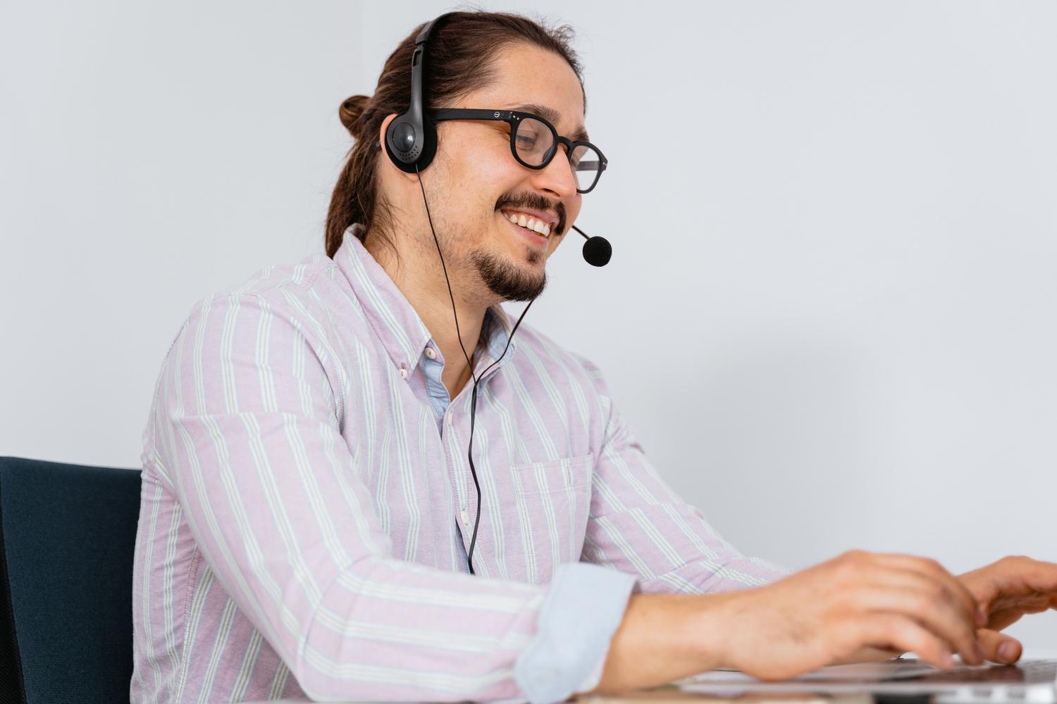Profesional utilizando auriculares con micrófono durante una llamada.