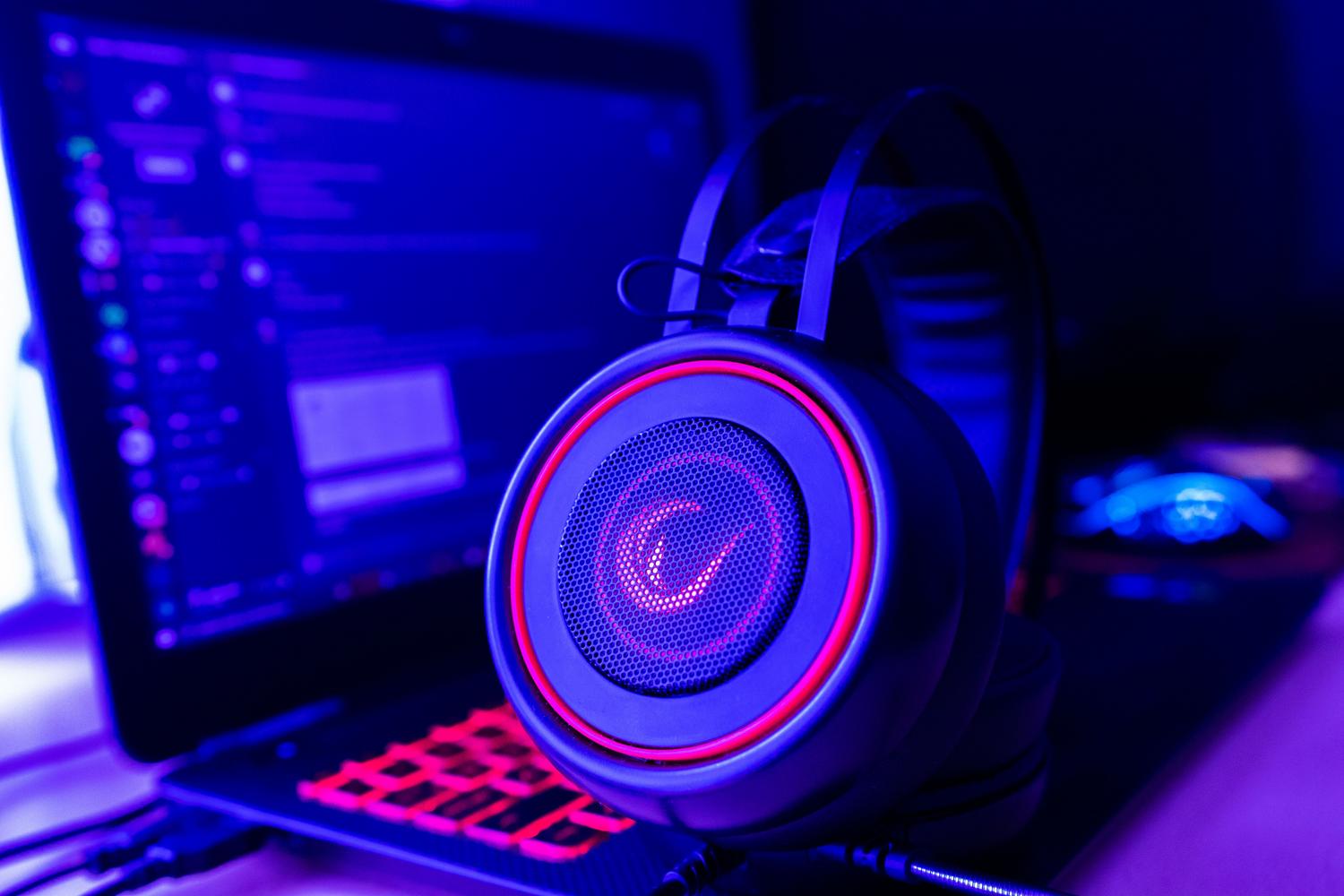 Auriculares gaming conectados a un portátil, representando posibles conflictos de controladores y mejoras de audio.