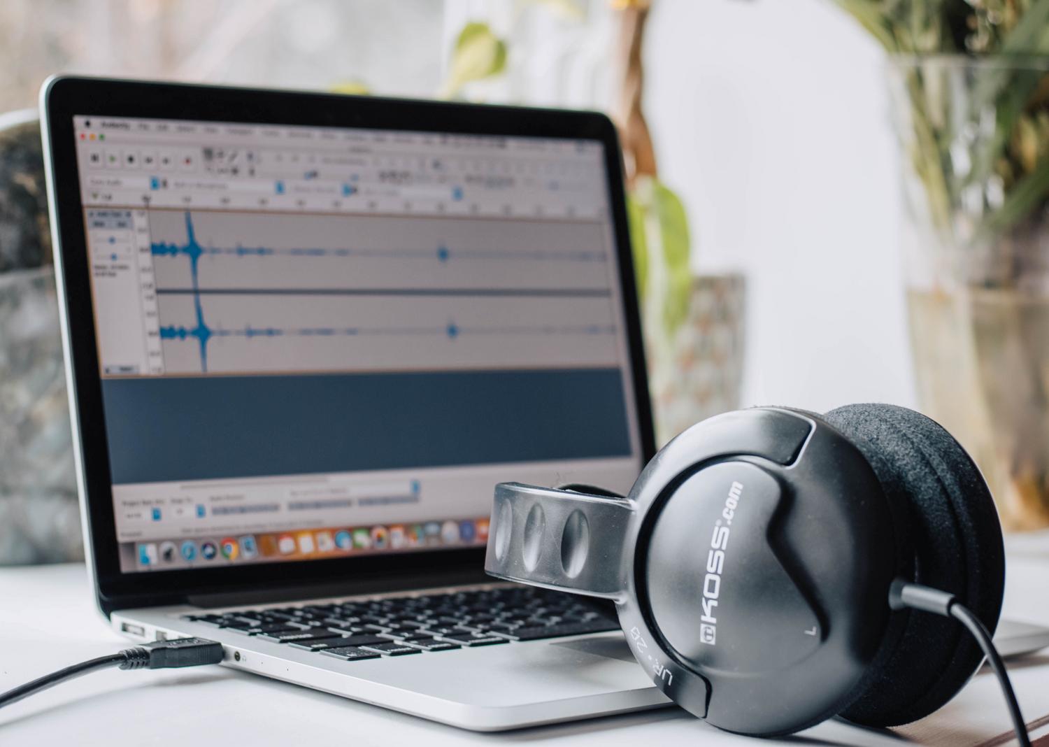 Auriculares sobre un portátil que representa los fallos de audiodg.exe y el procesamiento de sonido en Windows.