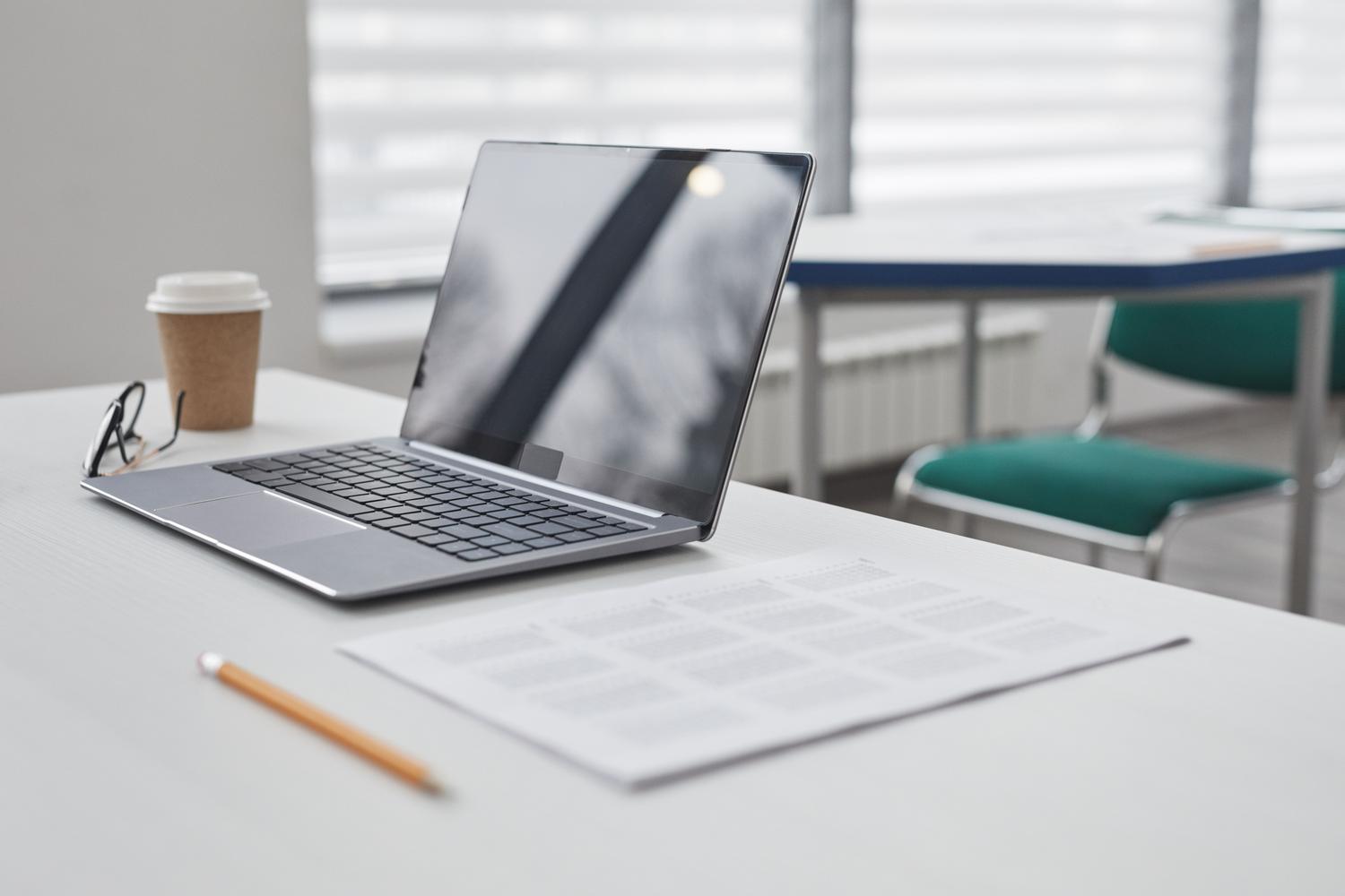 Escritorio minimalista con portátil y documentos, representando la revisión de calidad de un PDF comprimido.