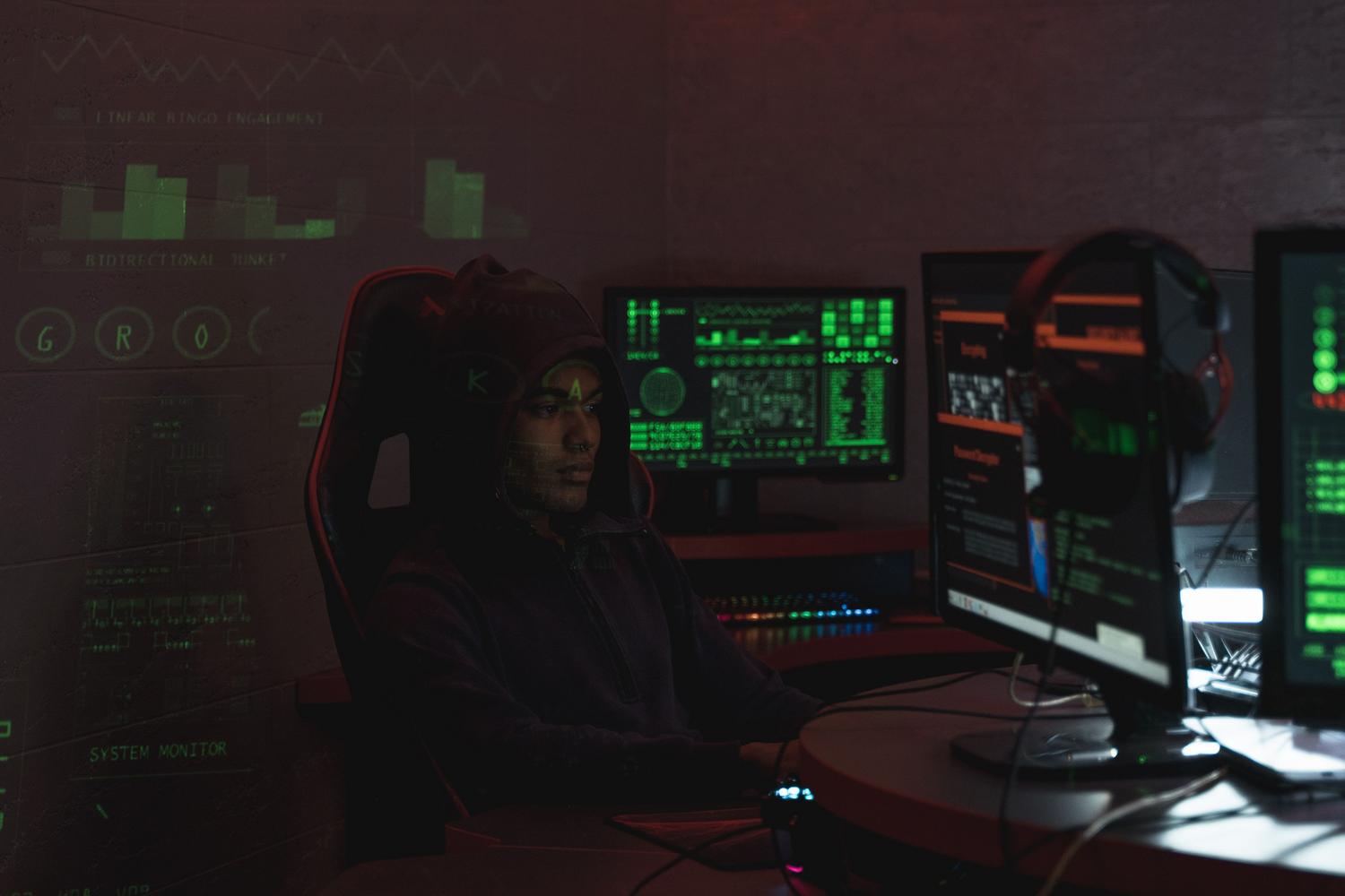 Atacante frente a varios monitores, representando la preparación de páginas falsas utilizadas en campañas ClickFix.