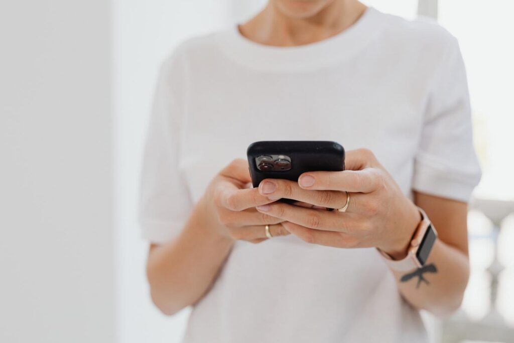 Persona utilizando un smartphone en un entorno interior, representando la facilidad de responder una encuesta digital.