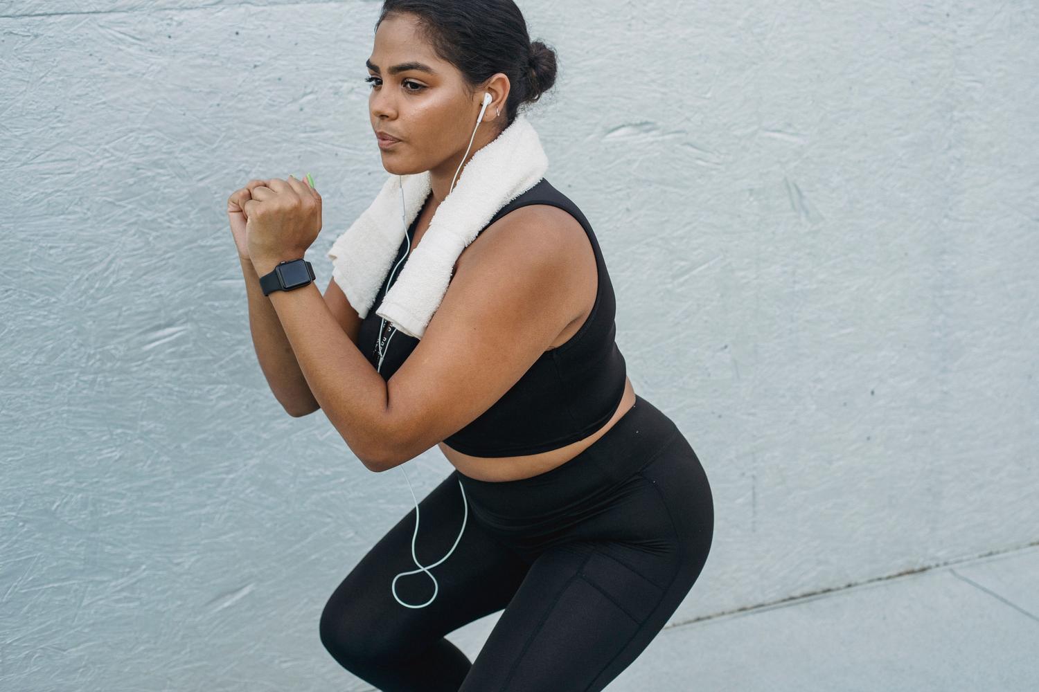 Mujer haciendo ejercicio con auriculares y un smartwatch que contiene archivos de música locales.