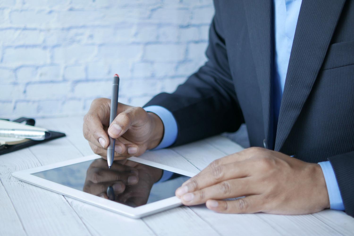 Usuario utilizando un lápiz digital para añadir una firma electrónica a un documento.