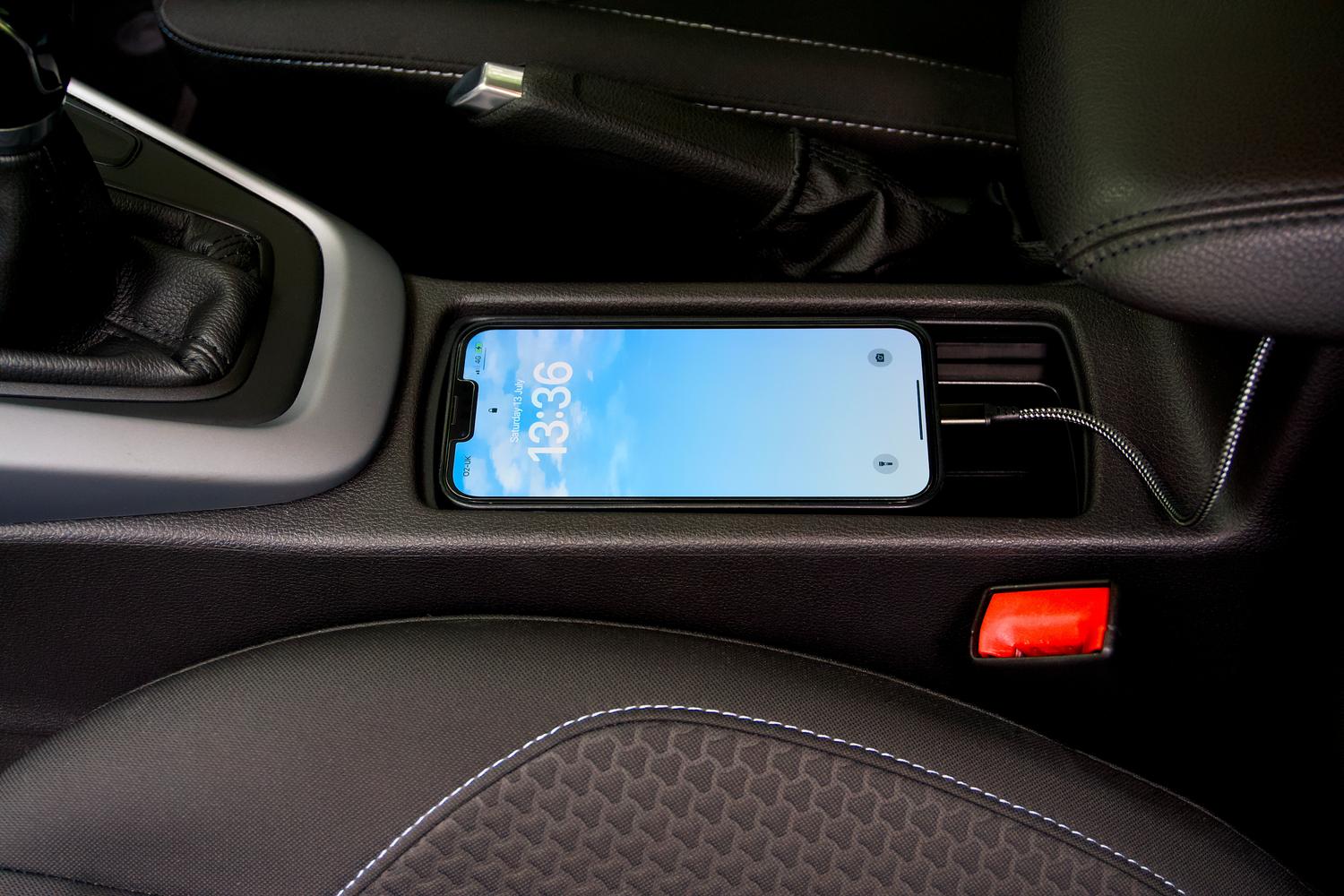 Smartphone colocado en la bandeja del coche para configurar y utilizar una llave digital mediante NFC