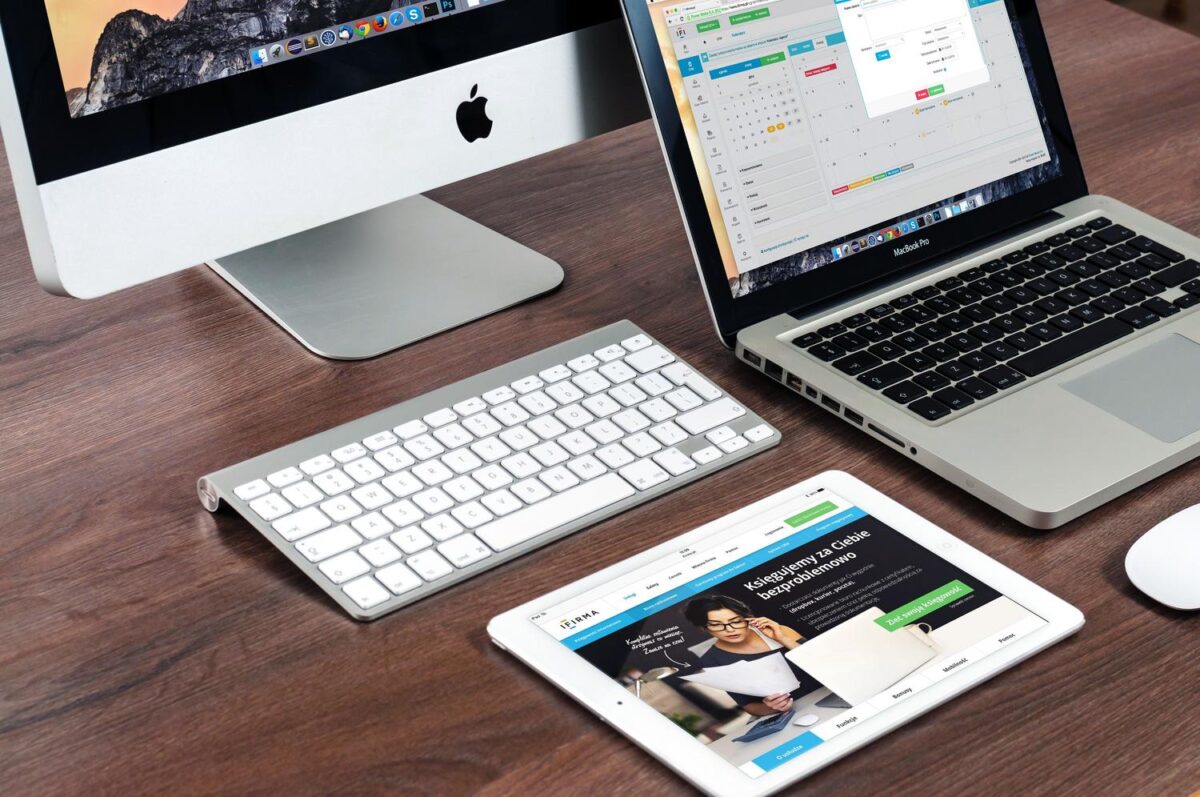 Escritorio moderno con iMac, MacBook y iPad, representando el ecosistema Apple y la integración con Synology Drive.