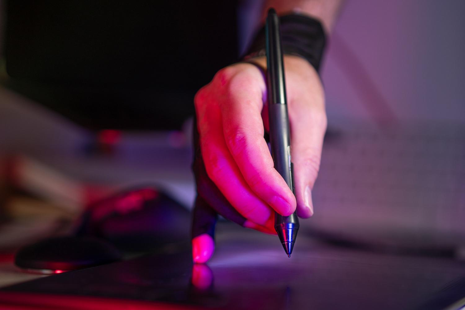 Diseñadora trabajando con formas y transiciones de color en una tableta gráfica.