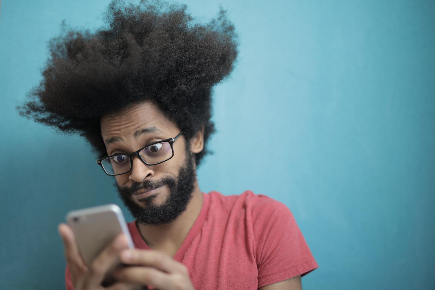 Hombre consultando información sobre aplicaciones desde su teléfono móvil