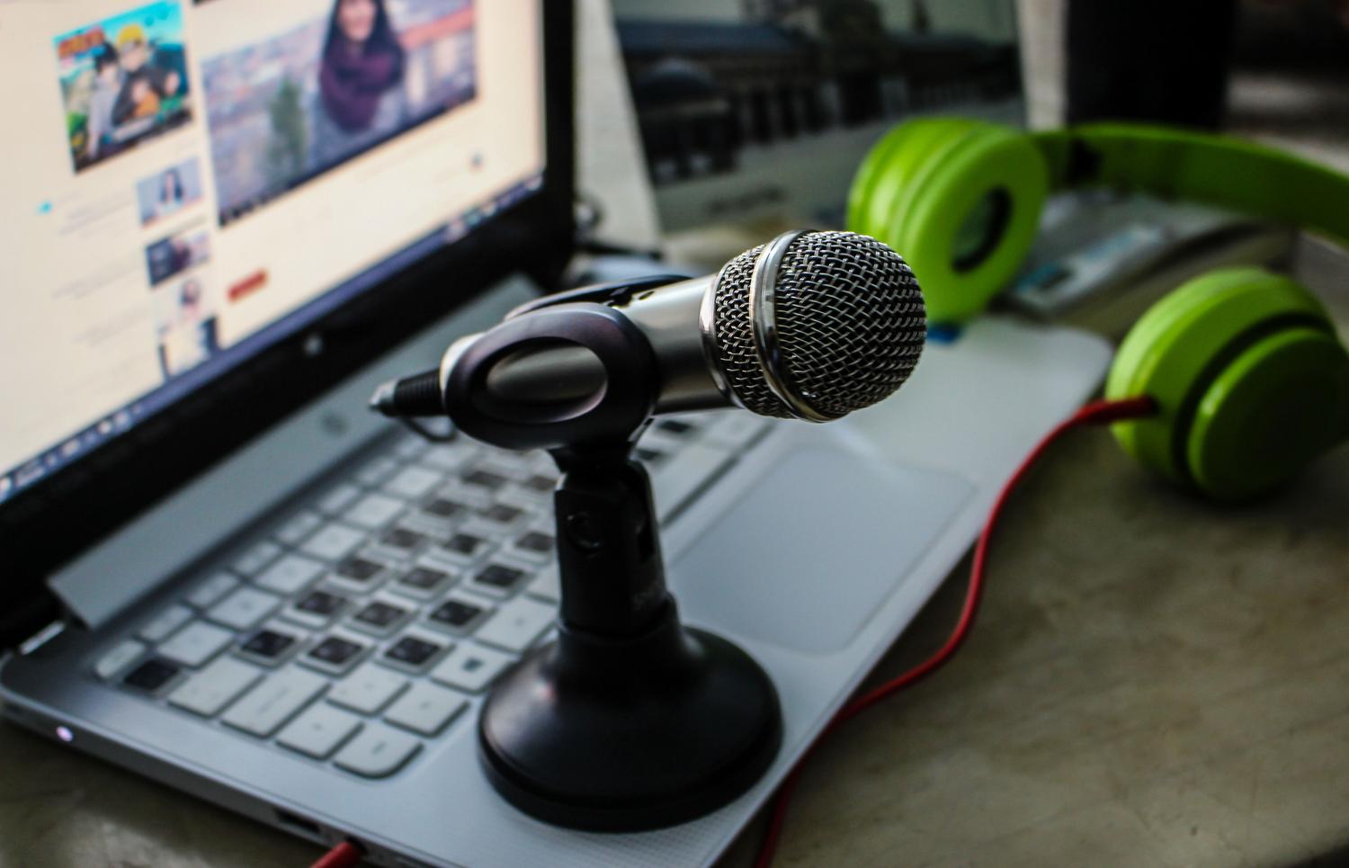 Micrófono, ordenador portátil y auriculares en un espacio de trabajo.