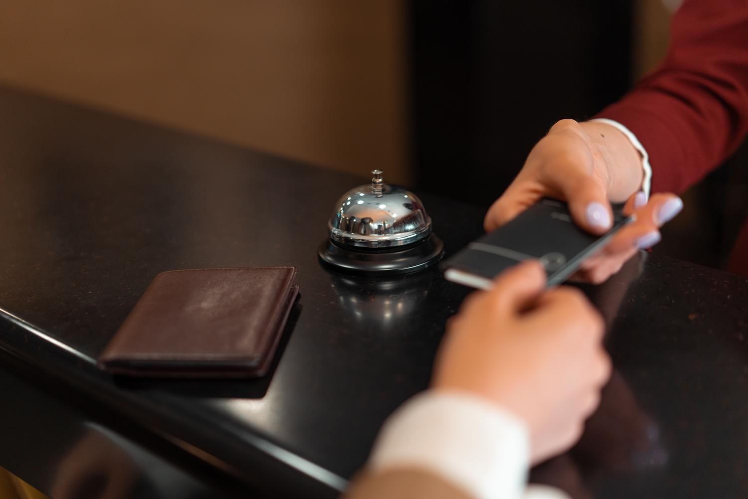 Proceso de check-in en la recepción de un hotel utilizando un smartphone, ilustrando la validez del DNI móvil.