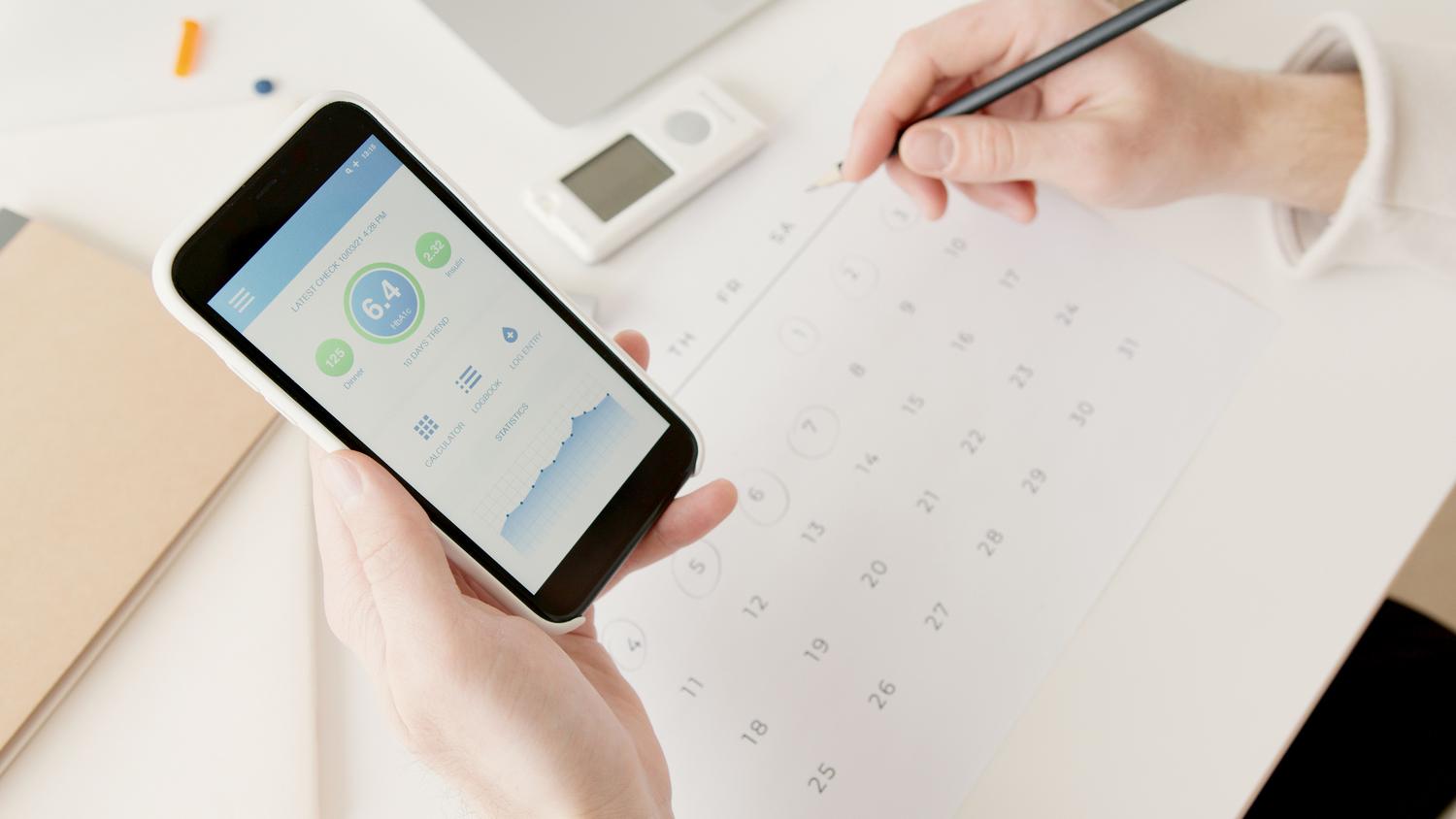 Manos utilizando un teléfono móvil para monitorizar estadísticas de salud y bienestar.