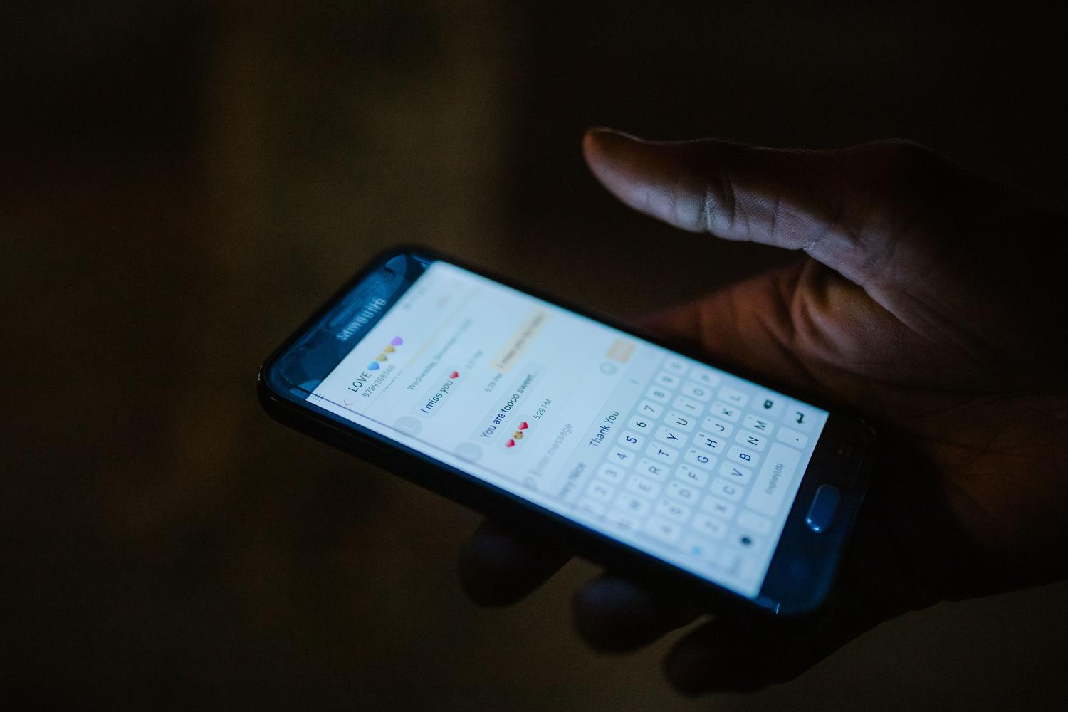 Persona utilizando una aplicación de mensajería en su teléfono móvil en un entorno cotidiano.