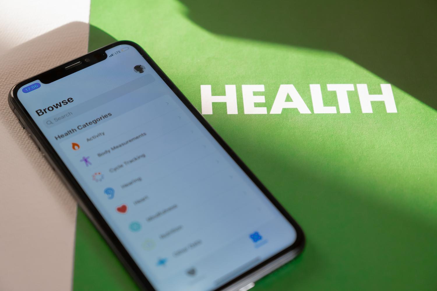 Smartphone mostrando una aplicación de salud sobre un fondo verde, ideal para introducir la gestión de bienestar digital.