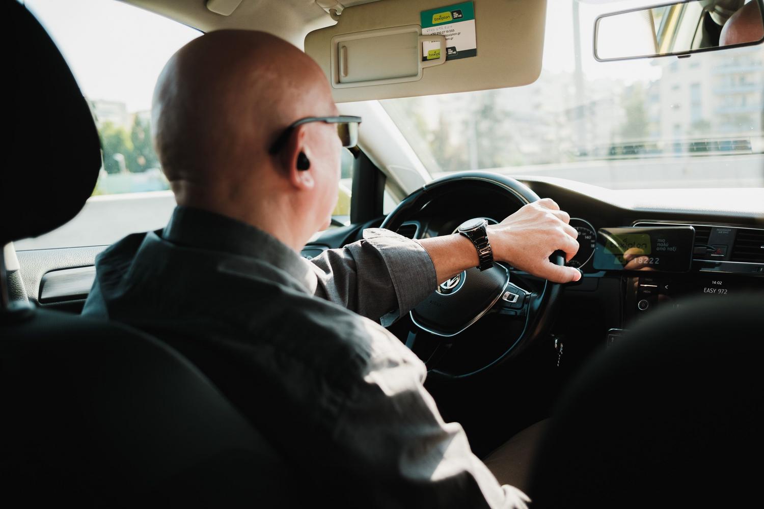 Hombre conduciendo un coche en un entorno urbano, aportando realismo al contexto de los desplazamientos diarios