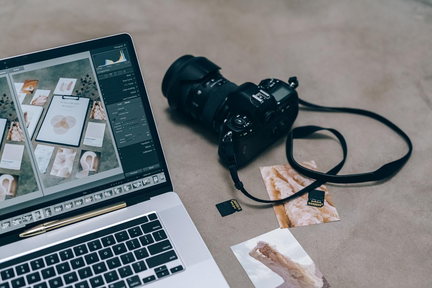 Escritorio de fotografía con ordenador portátil y software de edición, ilustrando el proceso de corregir imágenes.