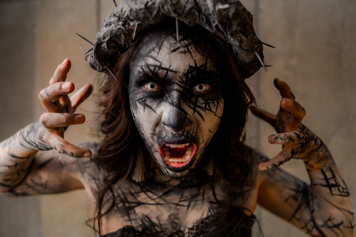 Retrato de terror gótico con maquillaje surrealista y accesorios impactantes.
