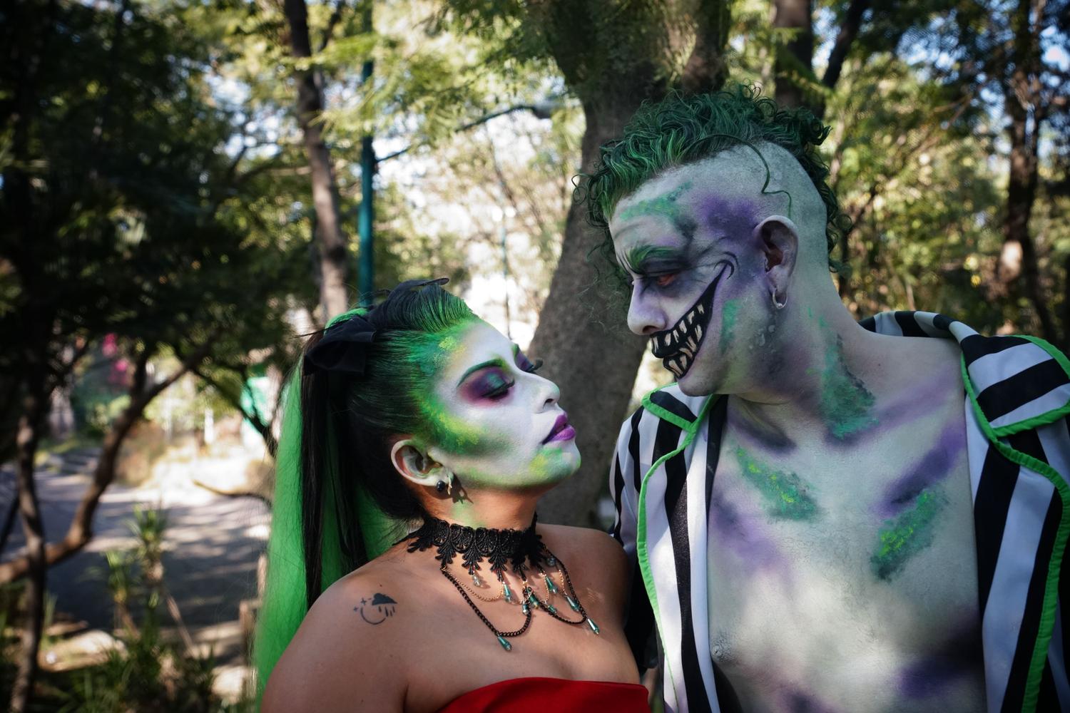 Pareja con disfraces coordinados y creativos en un parque.