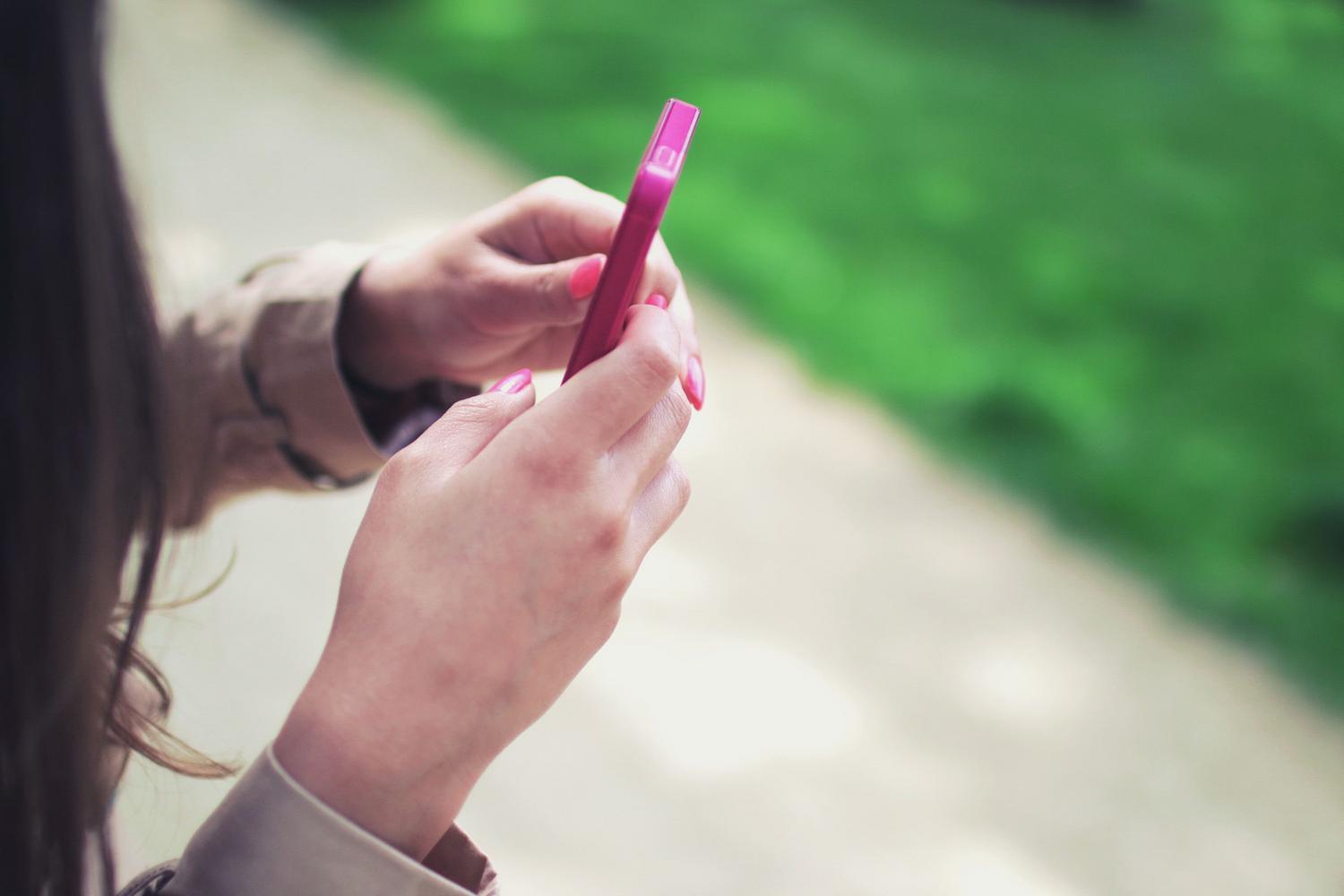 Persona interactuando de forma natural con un smartphone, simulando la navegación y gestión del feed de noticias.