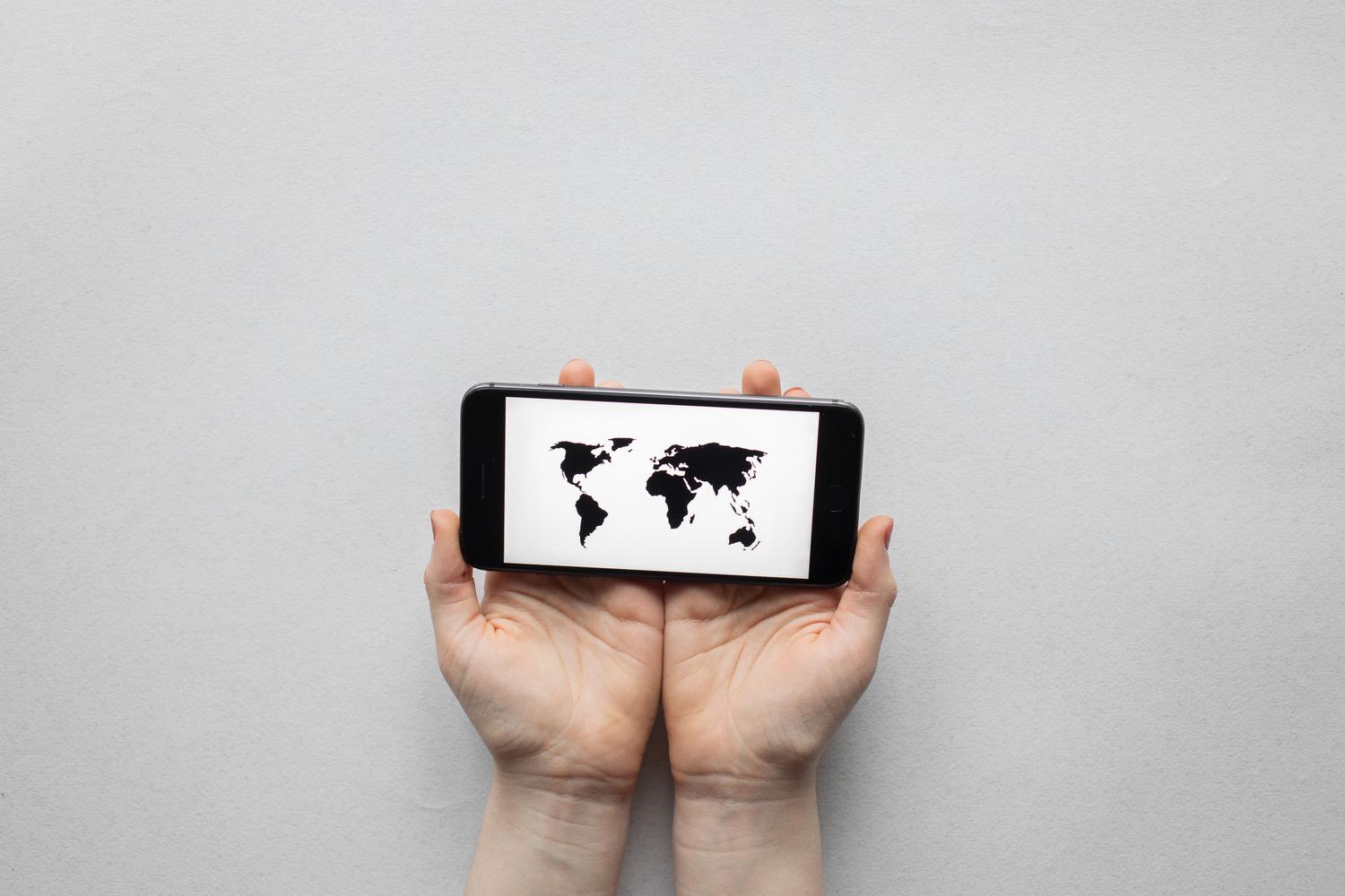 Smartphone mostrando un mapa mundial, simbolizando la comunicación global y la traducción de contenidos.