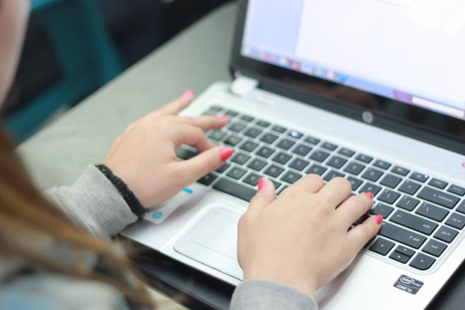 Primer plano de manos escribiendo en un teclado de portátil, simbolizando la edición y gestión de archivos digitales.