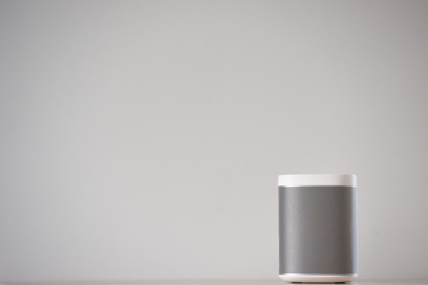 Primer plano de un altavoz inteligente moderno y minimalista en una superficie neutra. Primer plano de un altavoz inteligente moderno y minimalista en una superficie neutra.