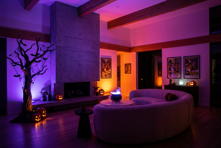 Salón moderno decorado para Halloween con iluminación inteligente en tonos púrpura y naranja, creando una atmósfera misteriosa y envolvente.