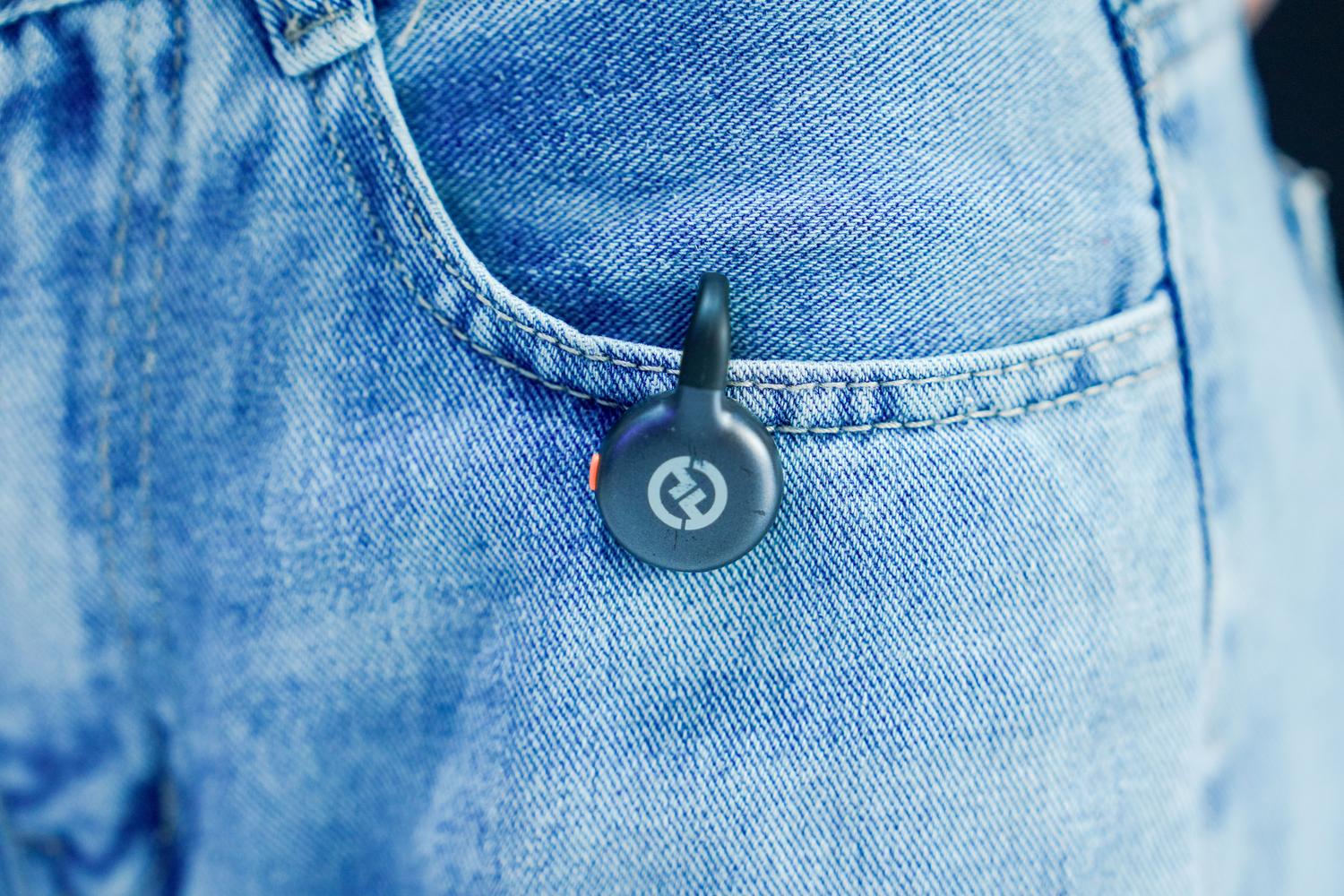 Primer plano de un rastreador Bluetooth genérico colocado en el bolsillo de un pantalón vaquero.