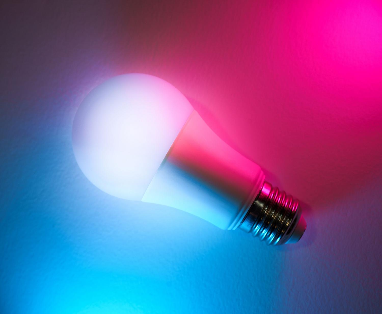 Bombilla LED inteligente con iluminación de colores neón, representando la sincronización de luces en un hogar inteligente.