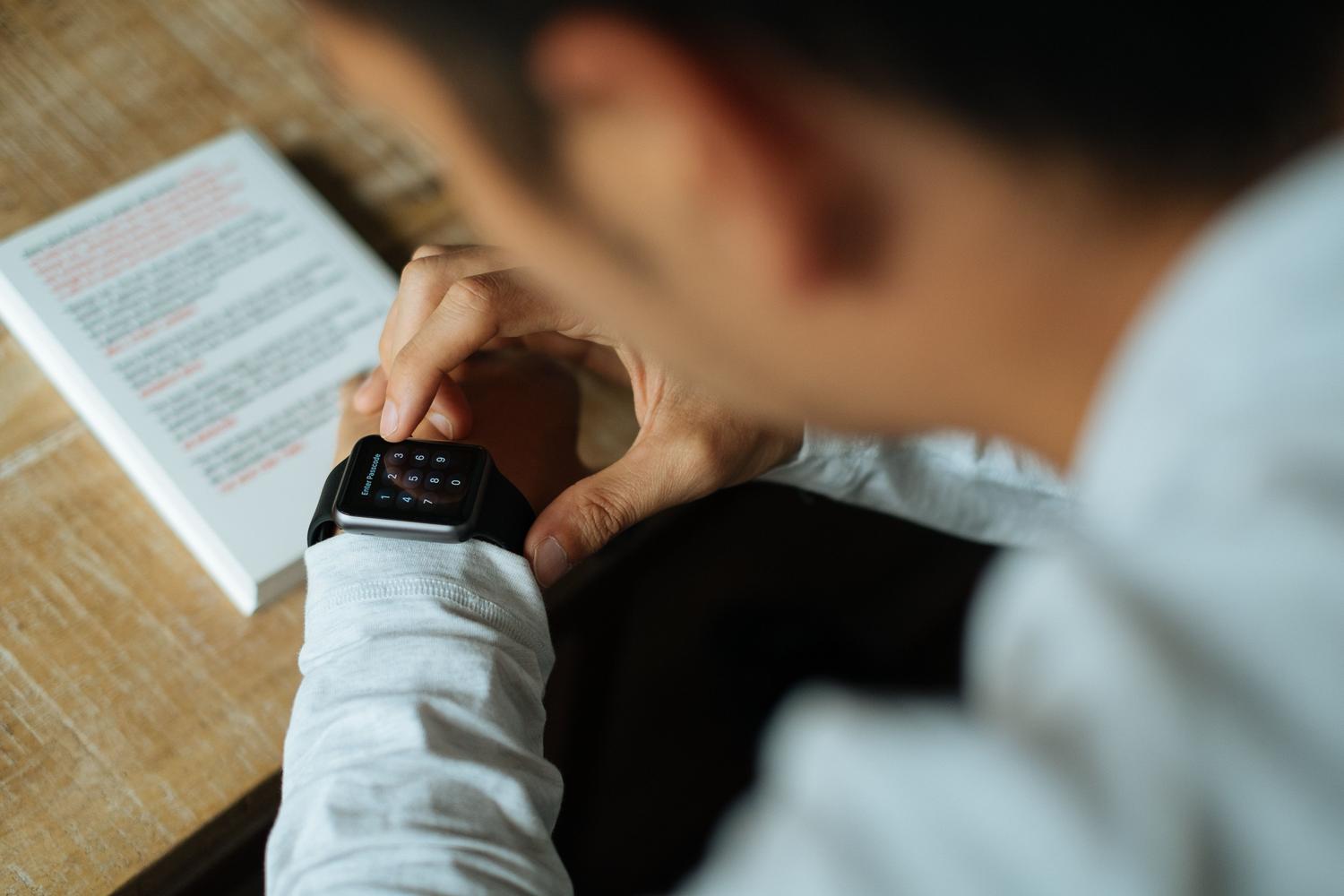 Usuario interactuando con la pantalla de un smartwatch para gestionar el acceso y las alertas.