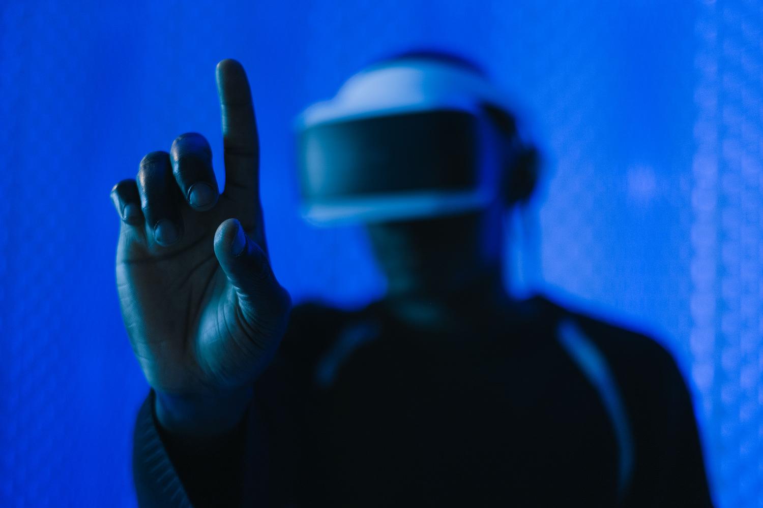 Primer plano de una mano interactuando con el aire mientras se usa un visor de realidad virtual, ilustrando la navegación y el seguimiento de manos de Meta Quest.