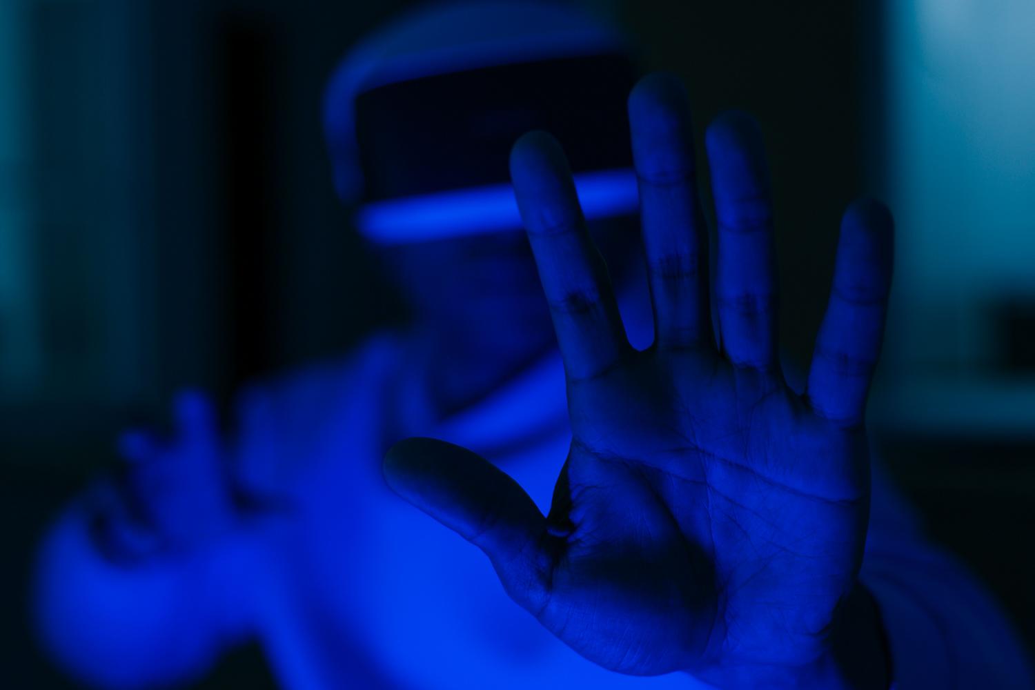 Persona interactuando en un entorno virtual con iluminación azul futurista, evocando la experiencia de computación espacial y el ecosistema de Meta.