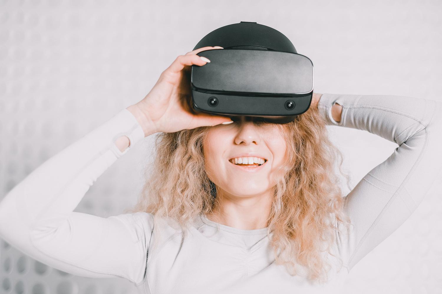 Mujer sonriendo y disfrutando de una experiencia de realidad virtual, transmitiendo la emoción de compartir el contenido con otros.