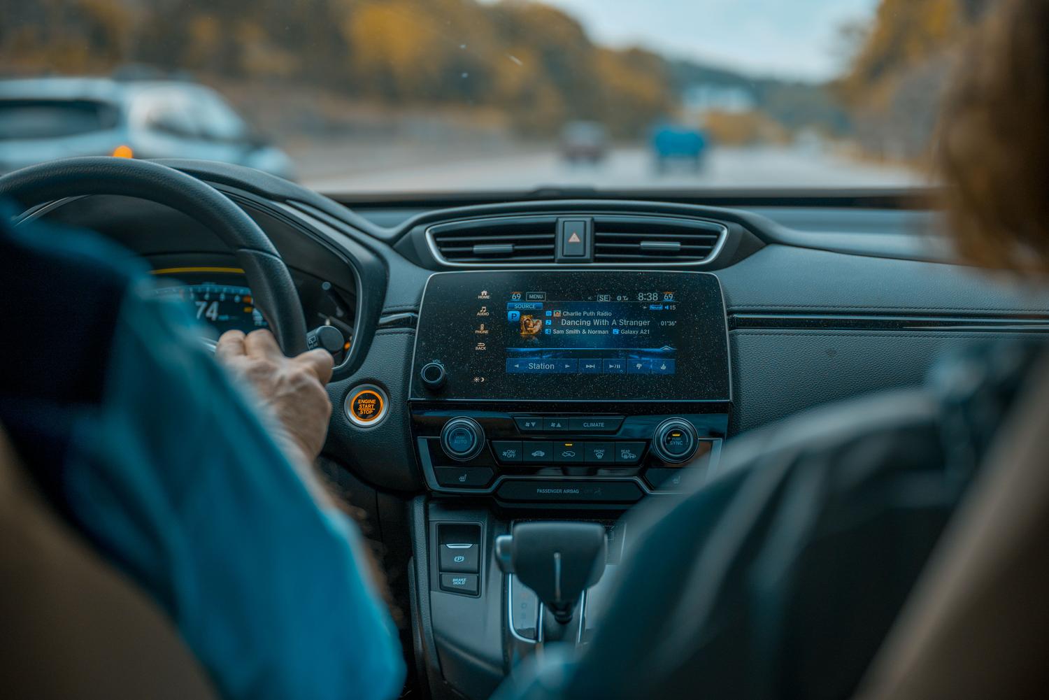 Primer plano del salpicadero y la pantalla de entretenimiento de un coche, resaltando la conectividad y el control multimedia.