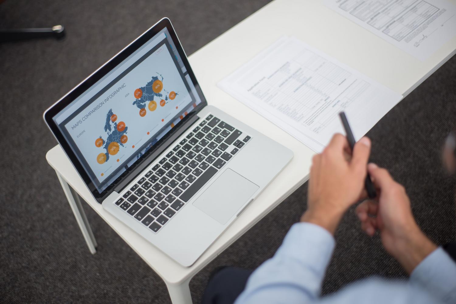 Profesional revisando datos y gráficos que incorporará a unas diapositivas.